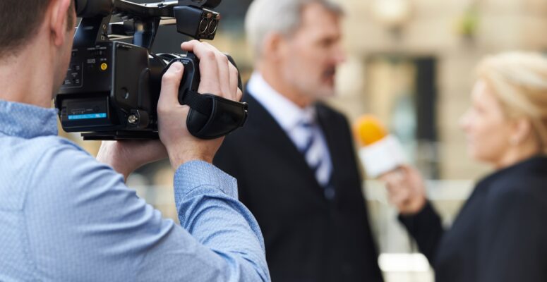 Hintergrundgespräch Medien - Mann filmt ein Intervie mit einer Kamera