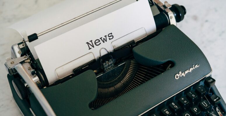 Schreibmaschine mit einem Blattpapier, auf dem News steht